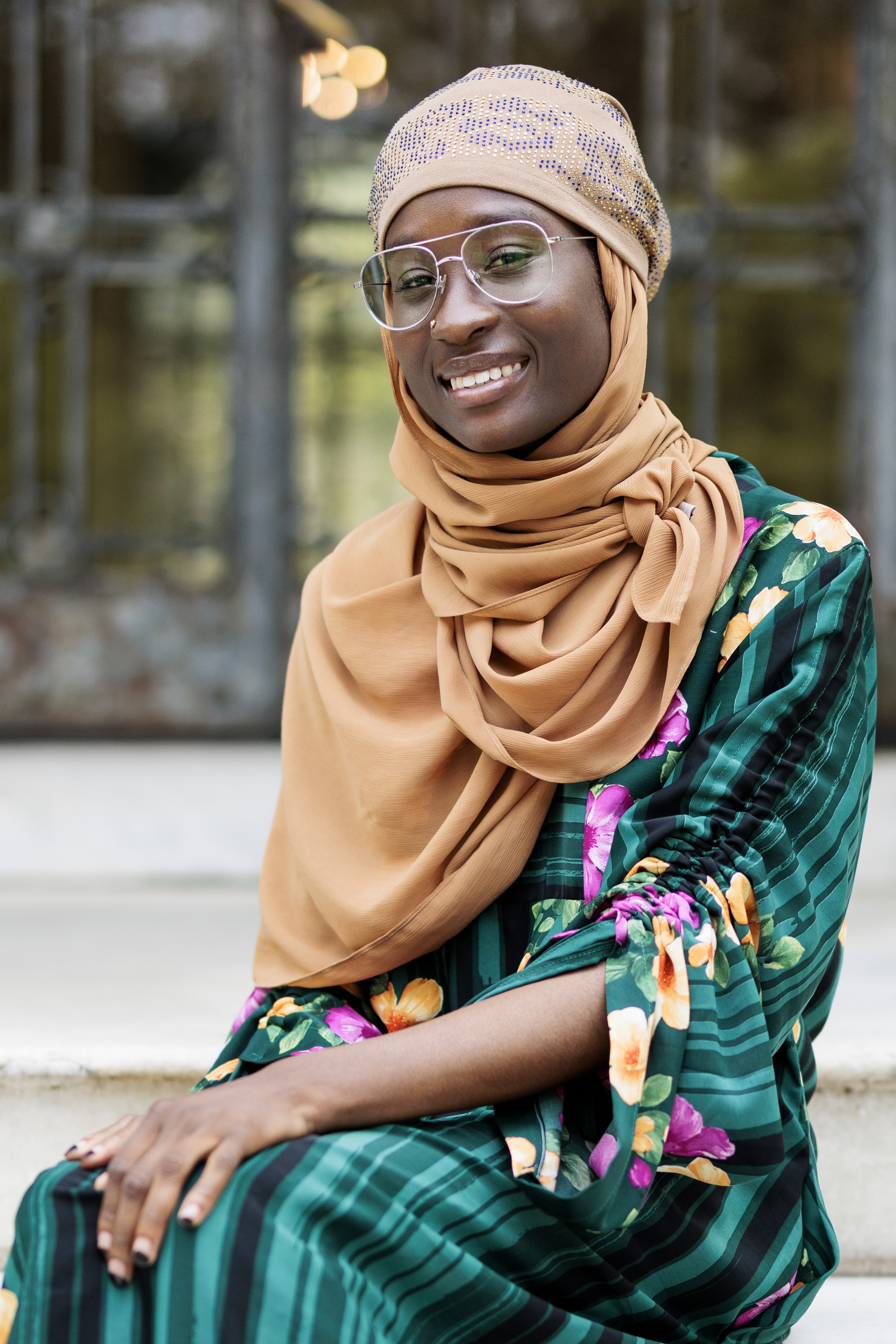 Kujegi Camara sitting in front of Cunniffe House Rose Hill Campus