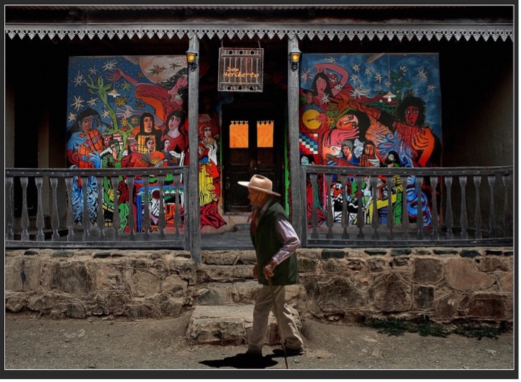 Man with mural in the background