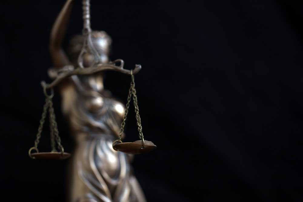 Lady Justice large statue in law on black backdrop