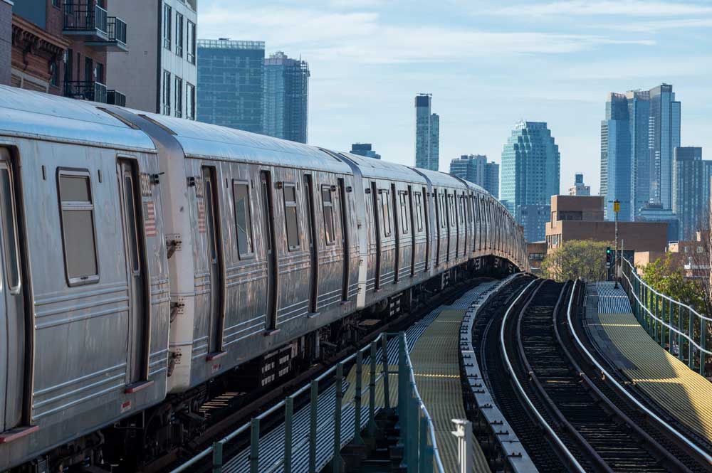 Stock image of NYC elevated subway with the city skyline