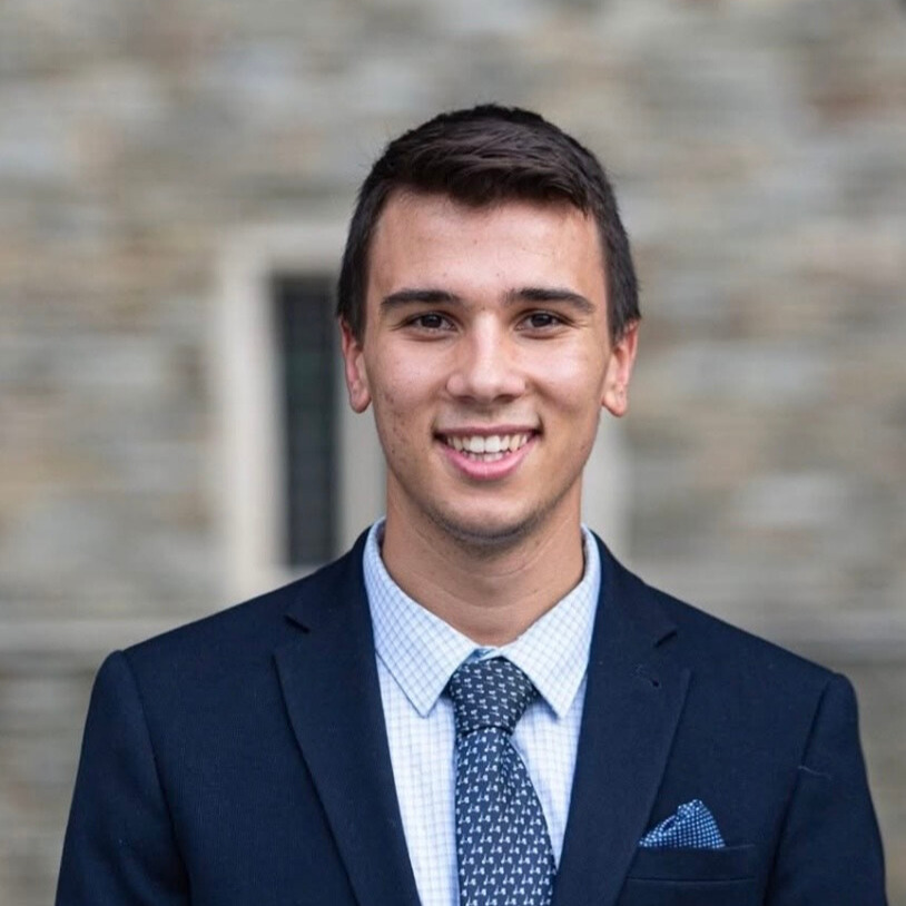 Max Ickes smiling in front of a grey background