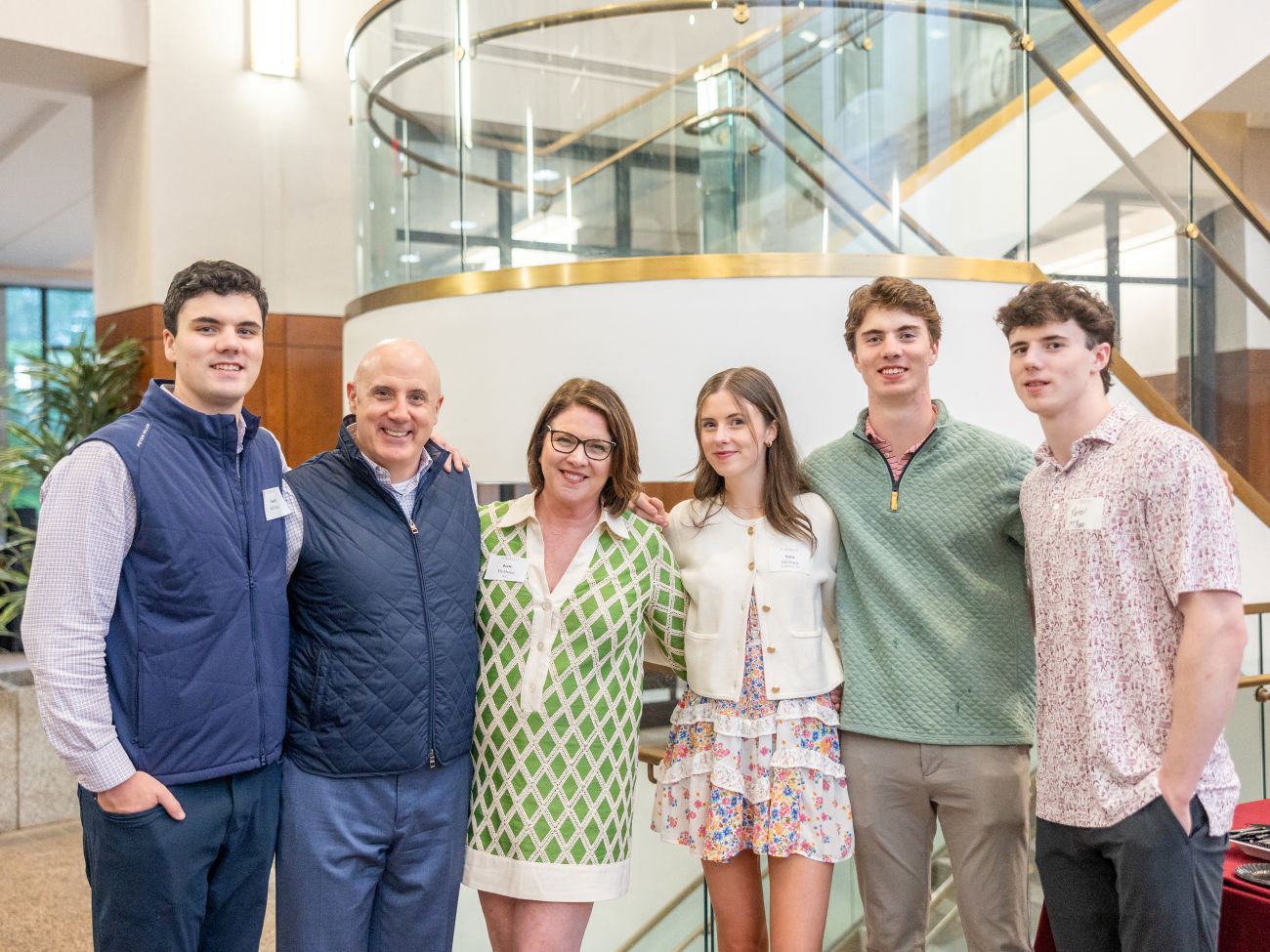 McShane family: parents and 3 children smiling together inside a building