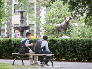 Two High School Students Sitting on a Bench in Front of the Rose Hill Ram Statue