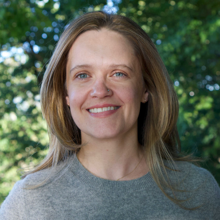 Casey smiling for a photo with a woodland background