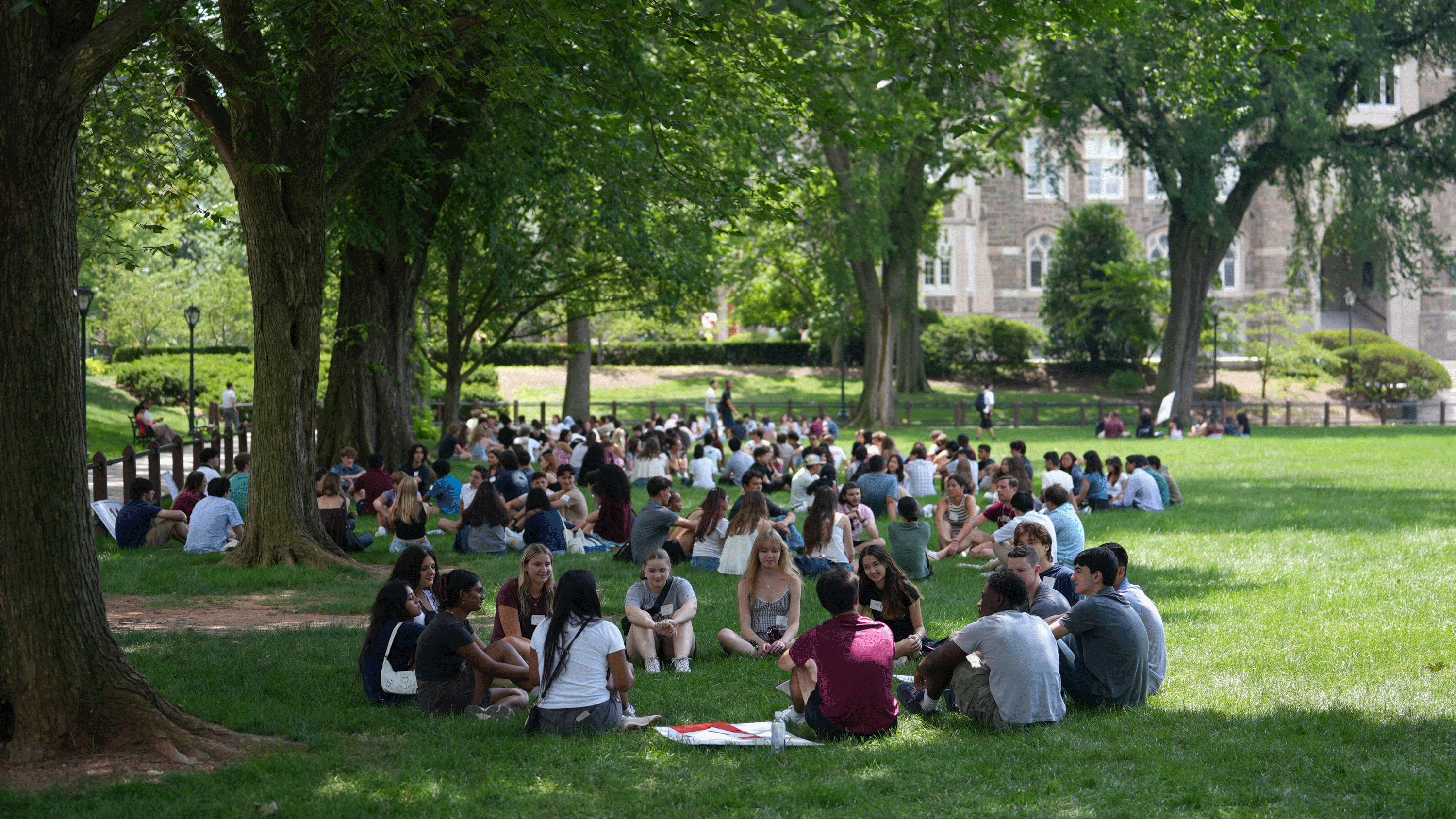 Groups of students meet in large circles on Eddies Parade on the Rose Hill campus during summer orientation