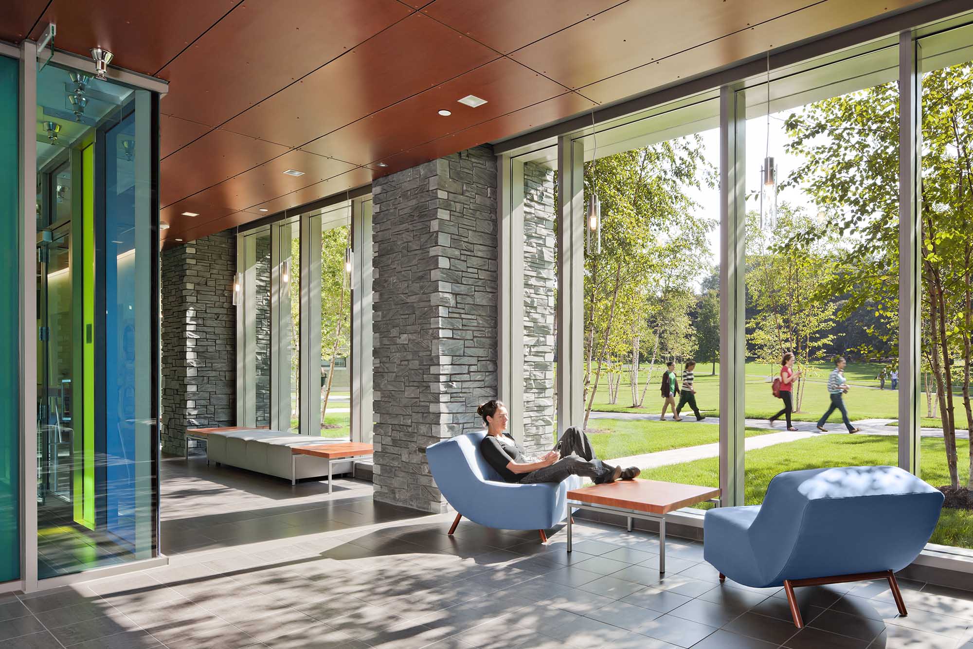 student sitting in lounge in Campbell, Salice, and Conley Hall