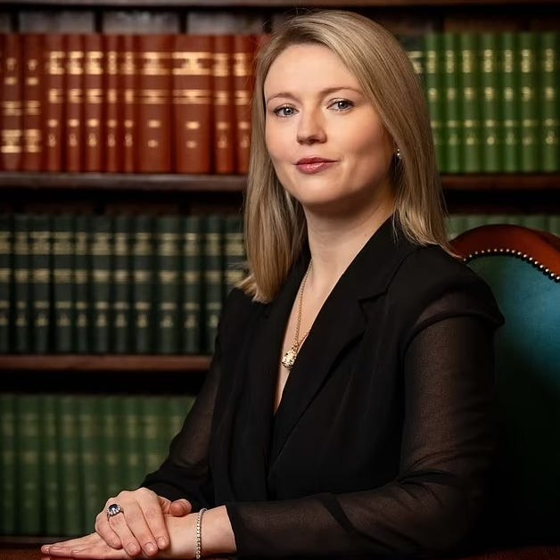 Charlotte Proudman with bookshelf in the background