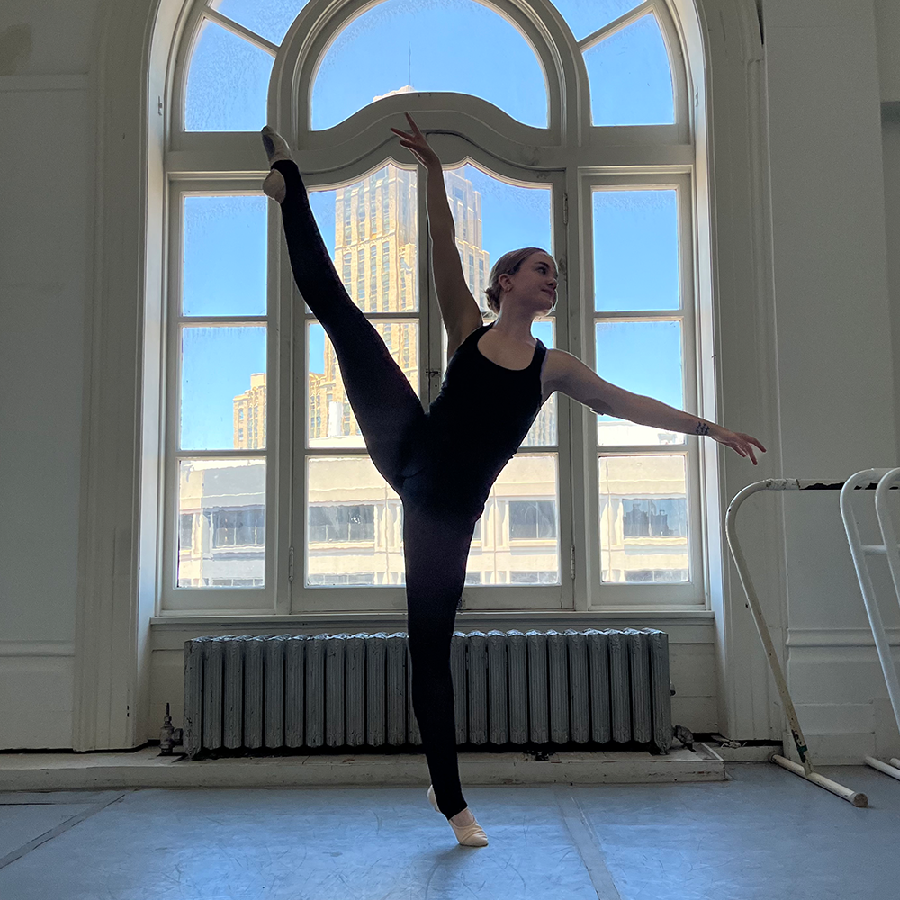 Dance student poses in front of window