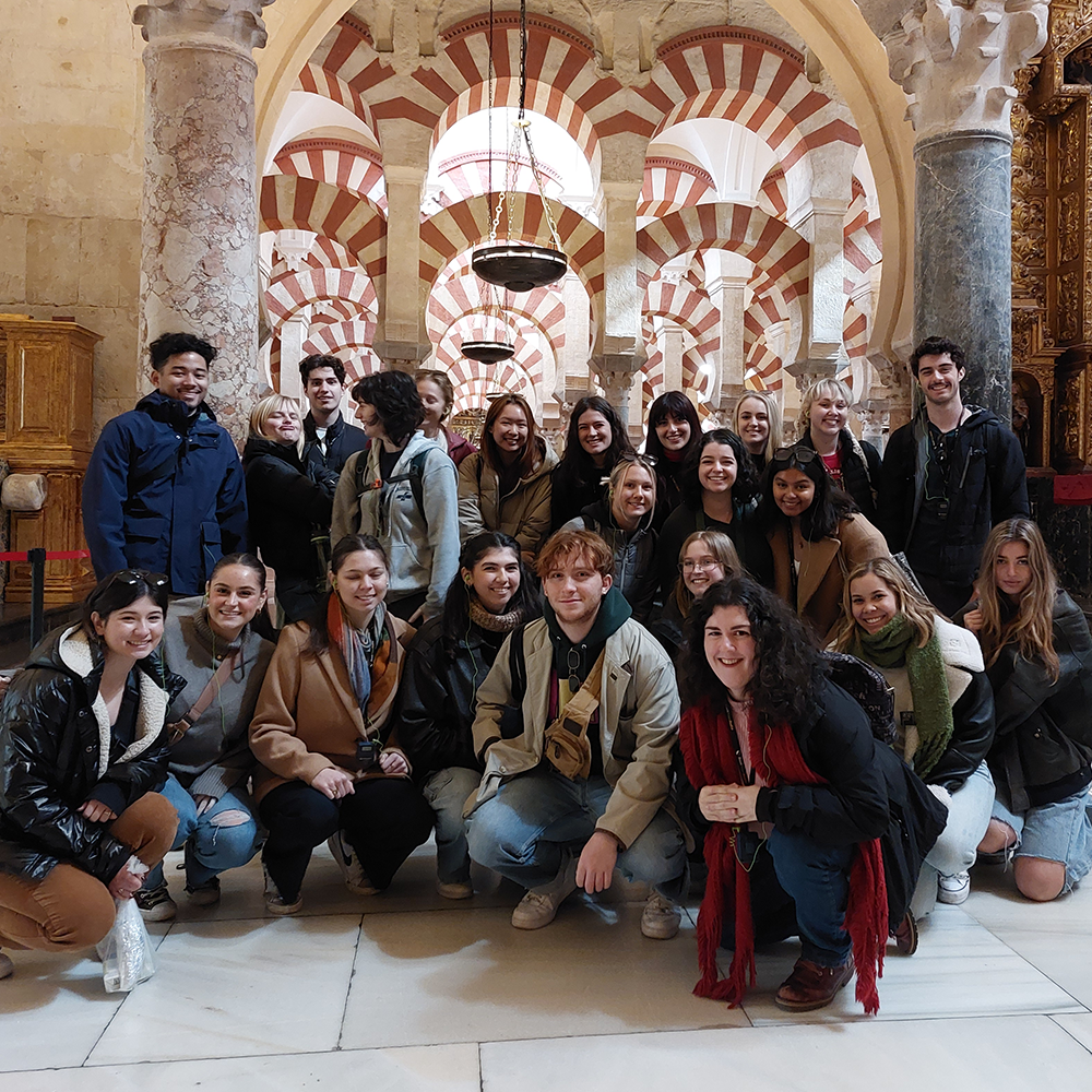 Students pose in front of historical building