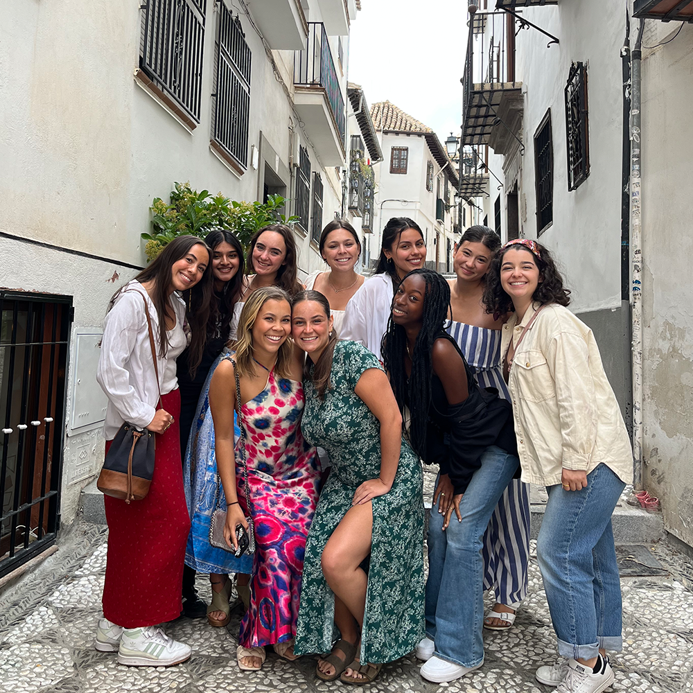 Students stand in front of Granada alleyway