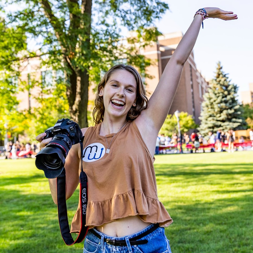 A student poses with a camera