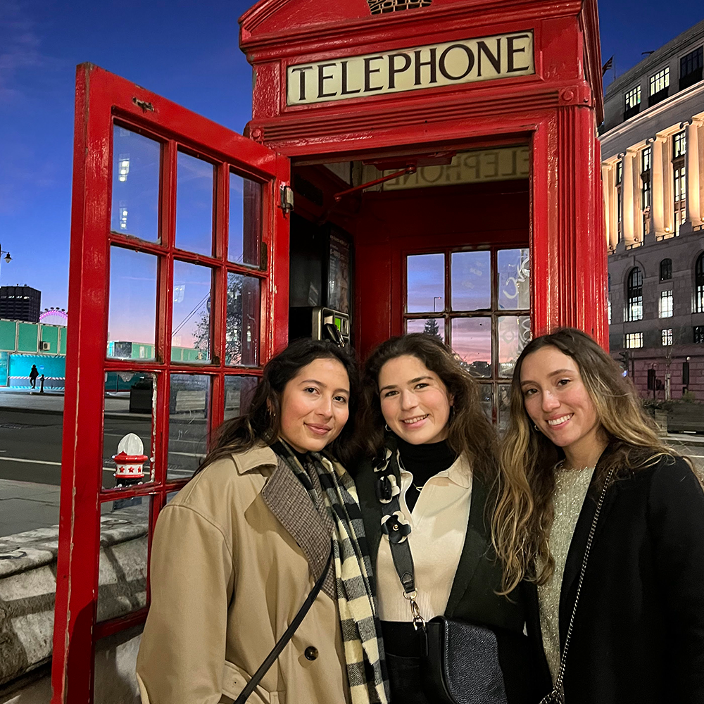 Students stand in front of UK telephone booth