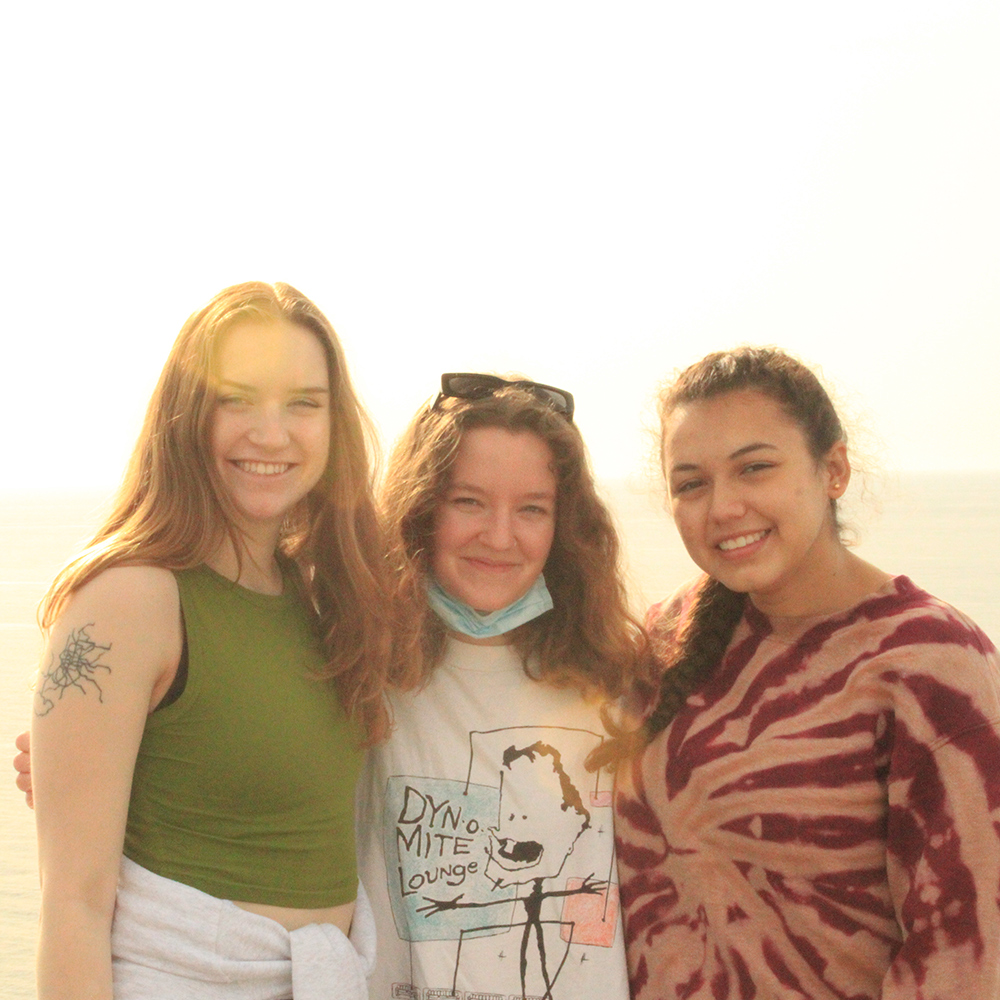 Students stand in front of setting sun