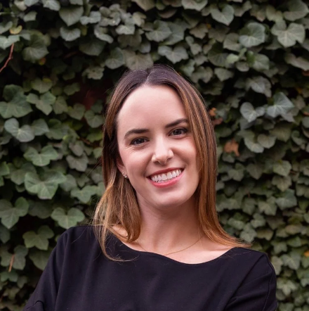 Olivia Vitali Headshot with ivy wall in background