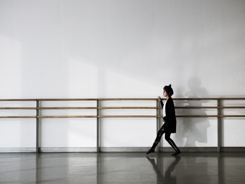Female student standing at ballet barre