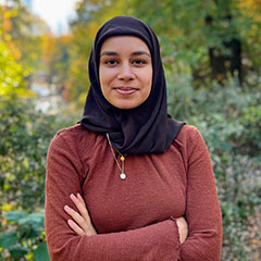 Faaria Fasih-Ahmad standing in front of trees