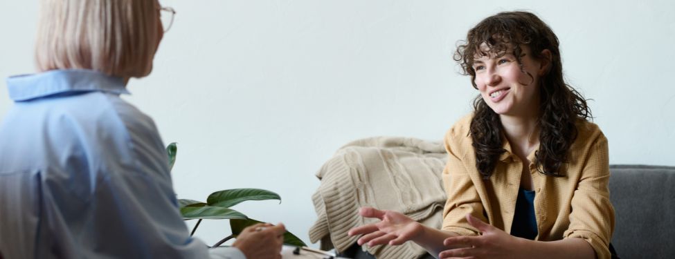 Social work therapist sits across from a client, giving the individual therapy.