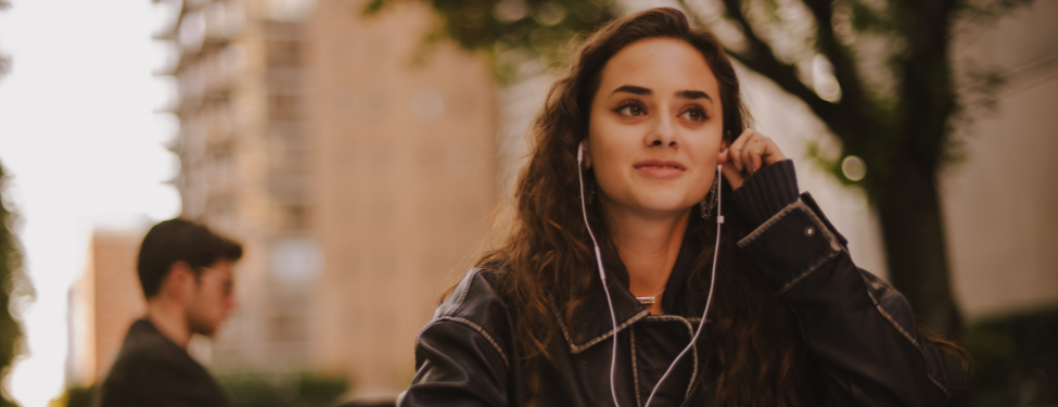 a student sits in Fordham's Lincoln Center campus courtyard with headphones on.