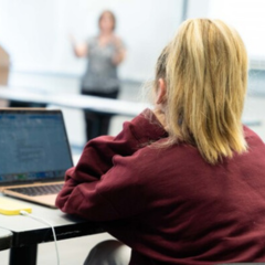 a student in a lincoln center campus classroom listening to a professor's lecture