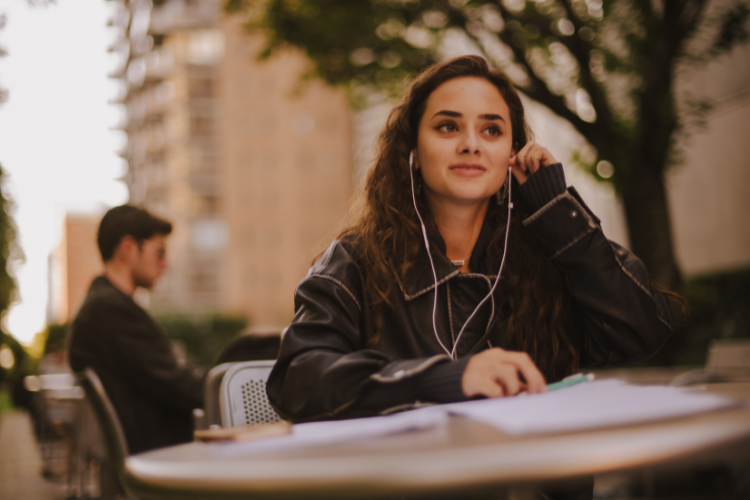 a student listening to music in the lincoln center campus courtyard