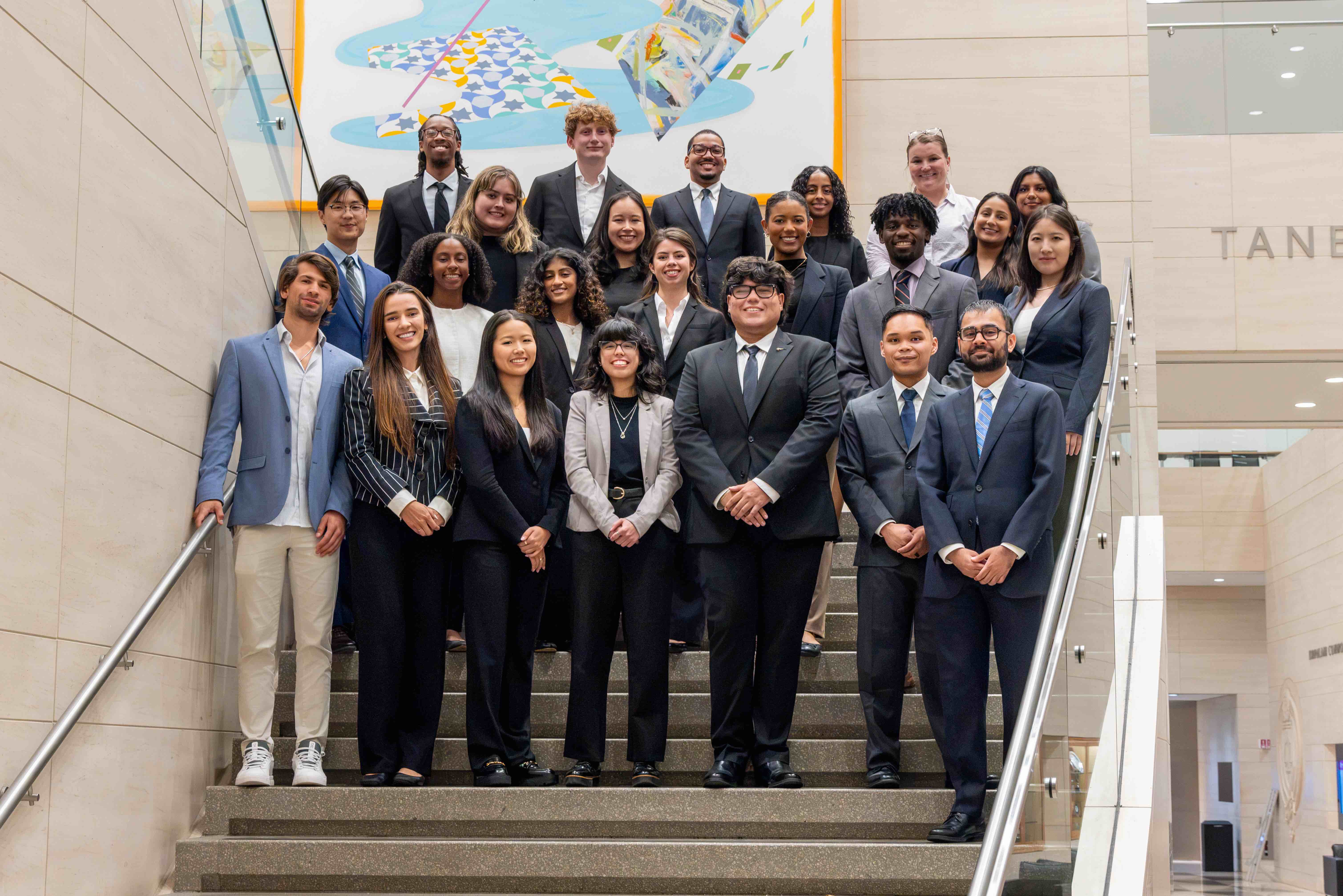 A group of students wearing suits standing on a staircase.