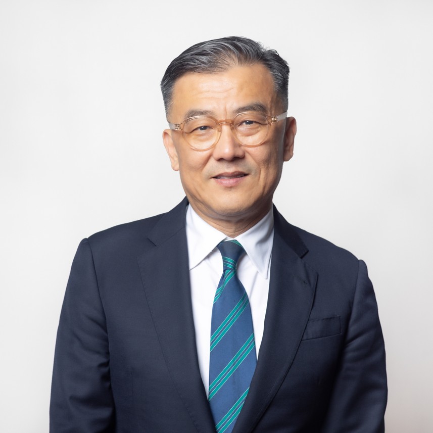 A man wearing glasses and a suit with blue tie.