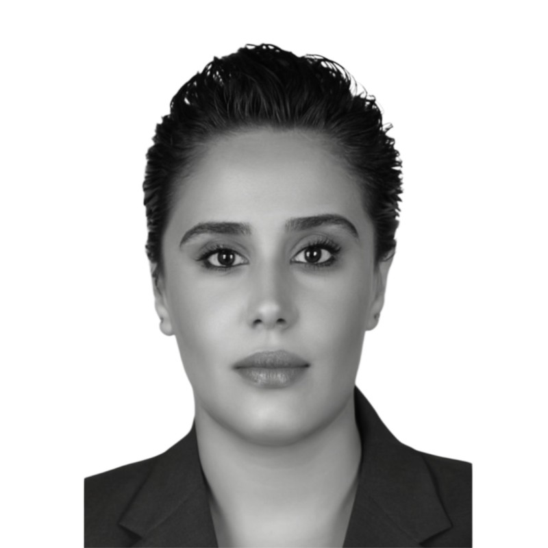 A woman with short hair wearing a dark top.