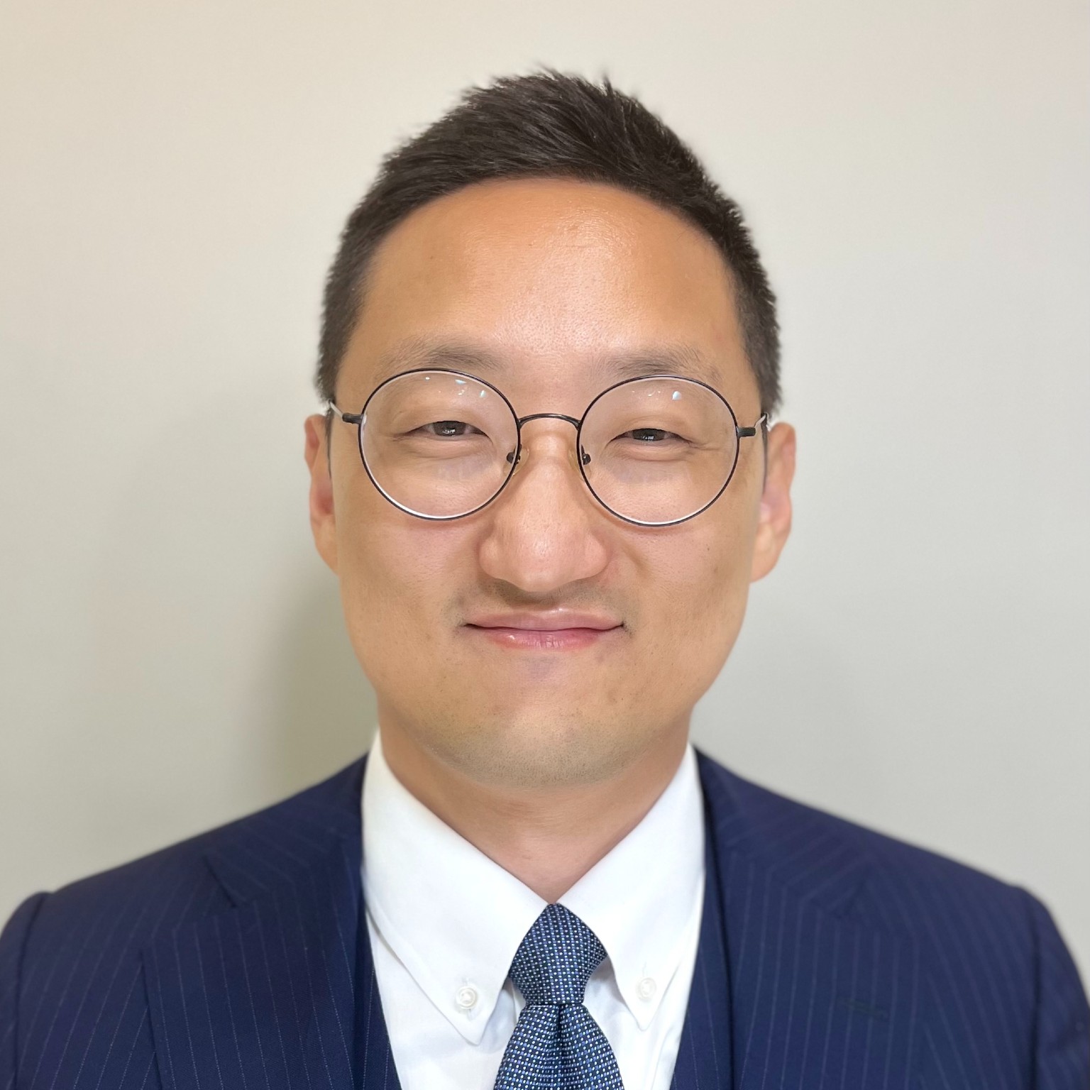 A man wearing a blue suit and glasses.