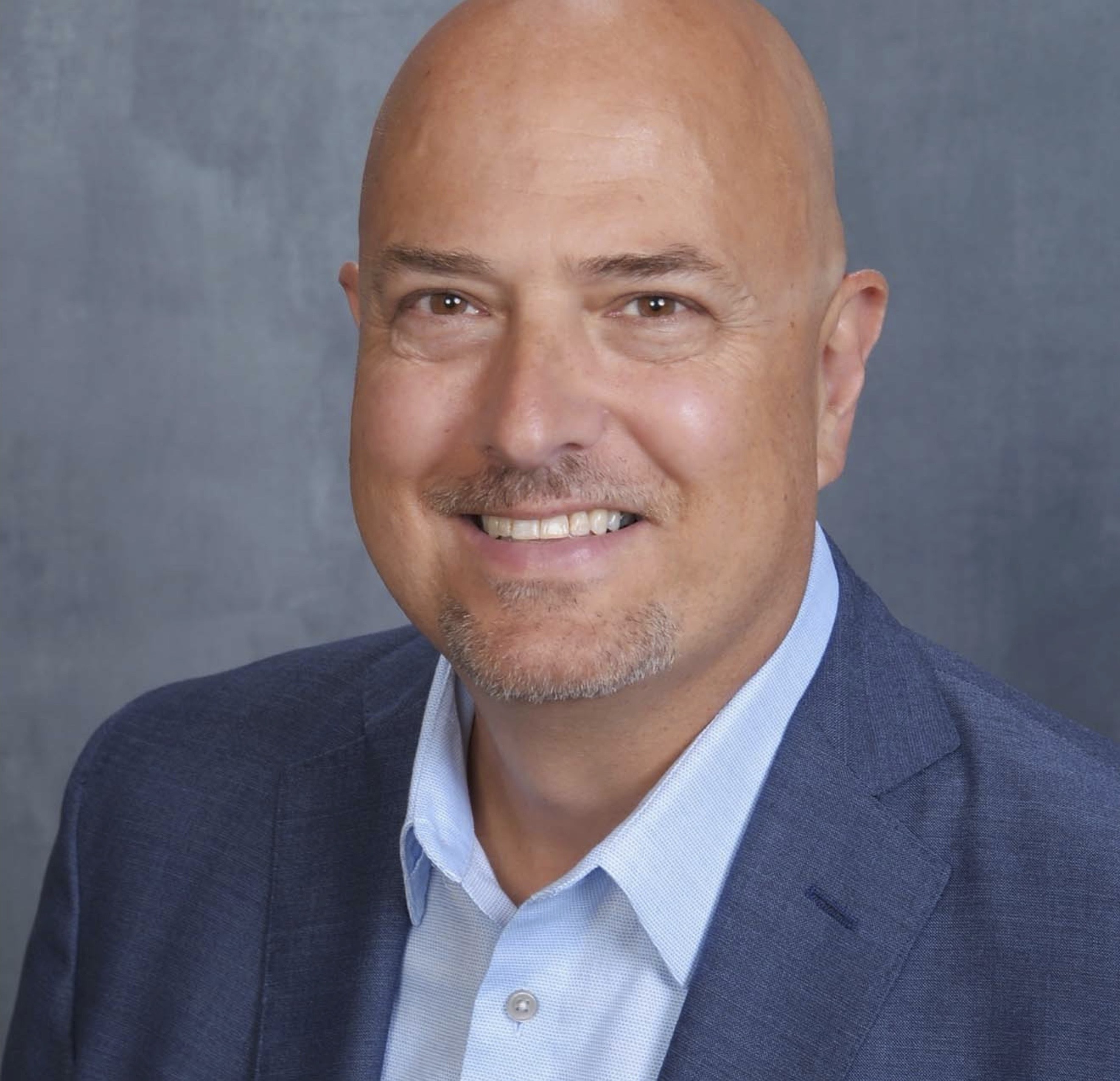 A man wearing a blue blazer with light blue shirt.
