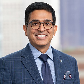 A man wearing glasses and a blue suit.