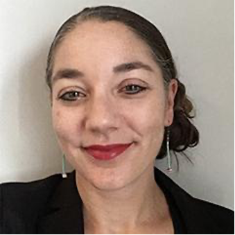 A woman with her hair tied in a bun wearing earrings and a black blazer.