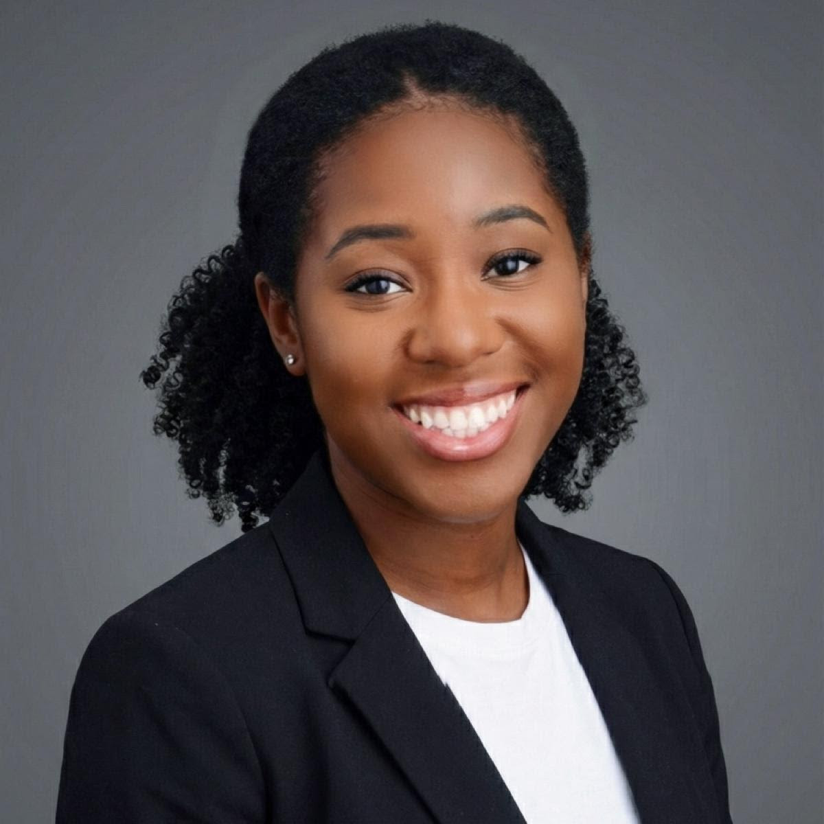 A woman wearing a black blazer and white shirt.