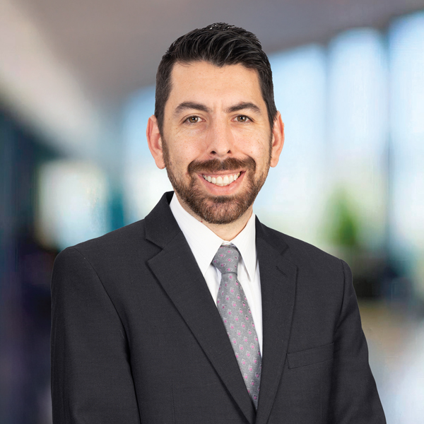 A man wearing a suit and tie standing in an office.