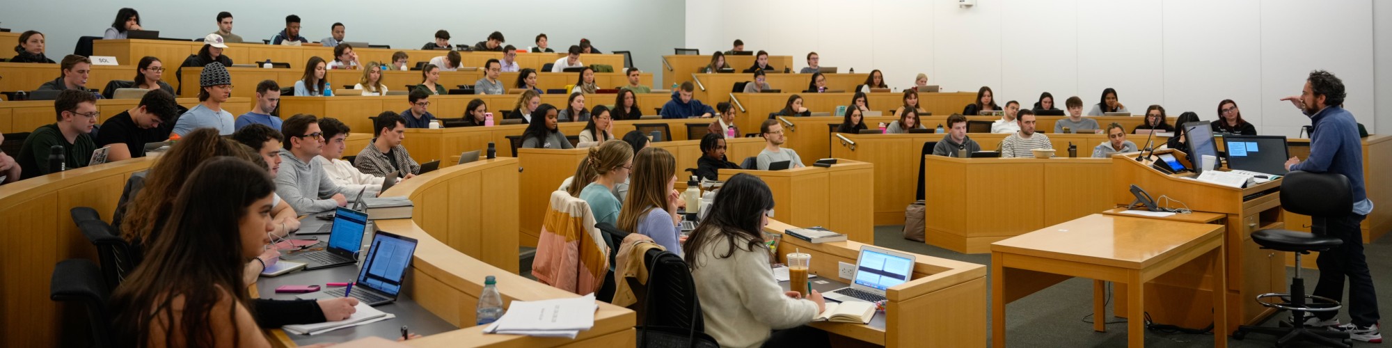 A professor lecturing to a classroom of students.