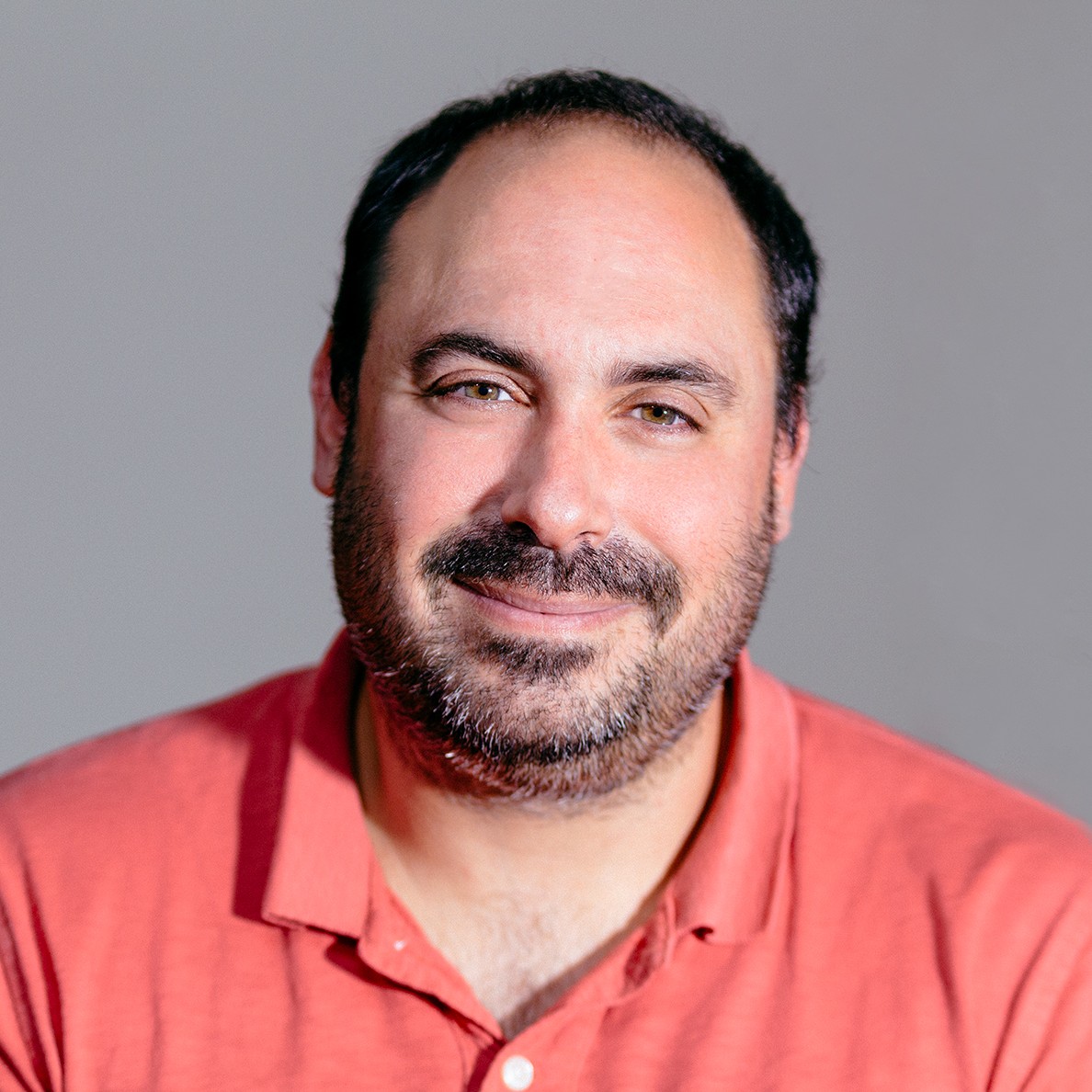 A man wearing a salmon pink shirt.
