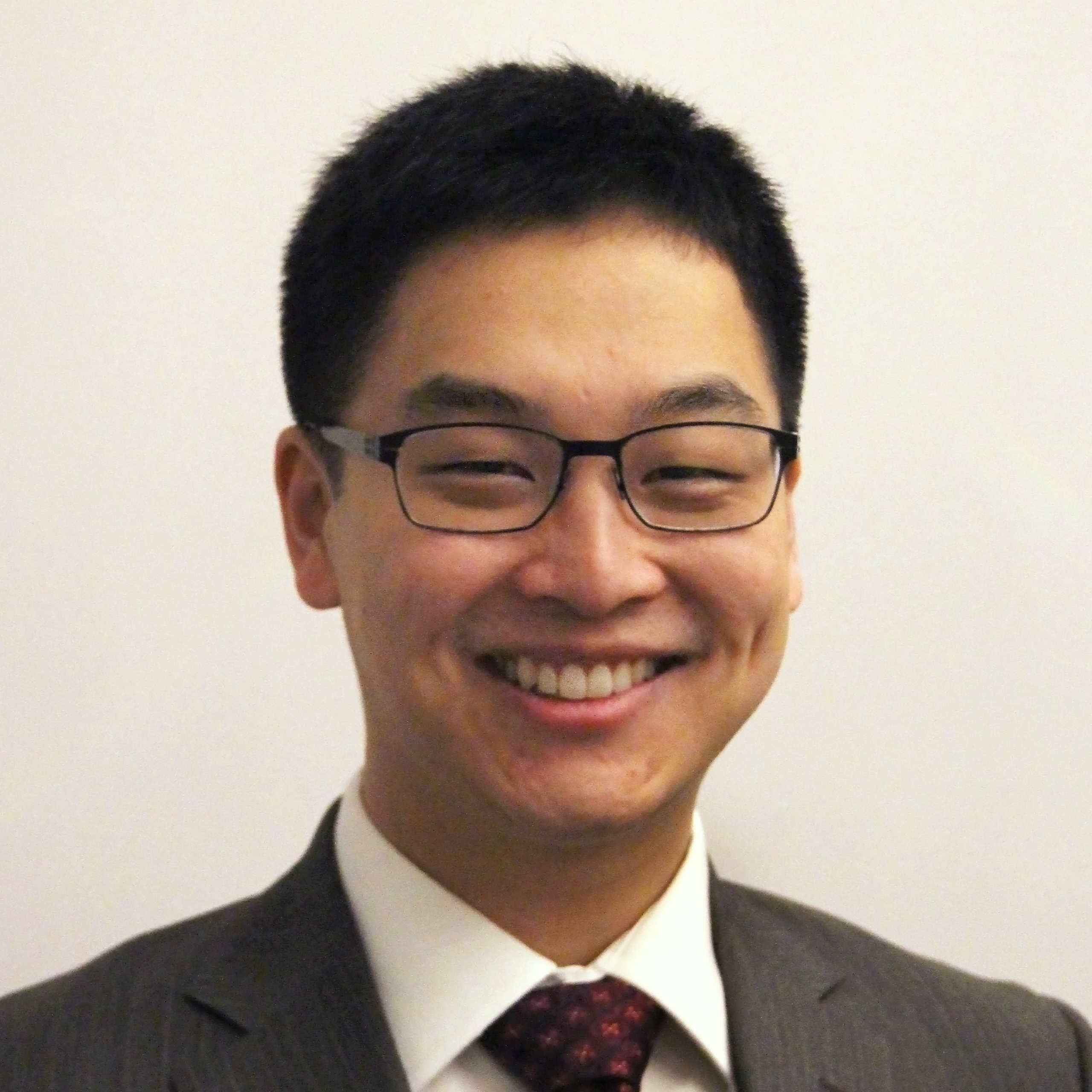 A man wearing glasses and a suit.