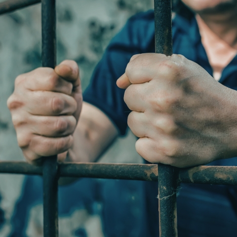 IRLLW Witness Series Image Man clenching bars in prison