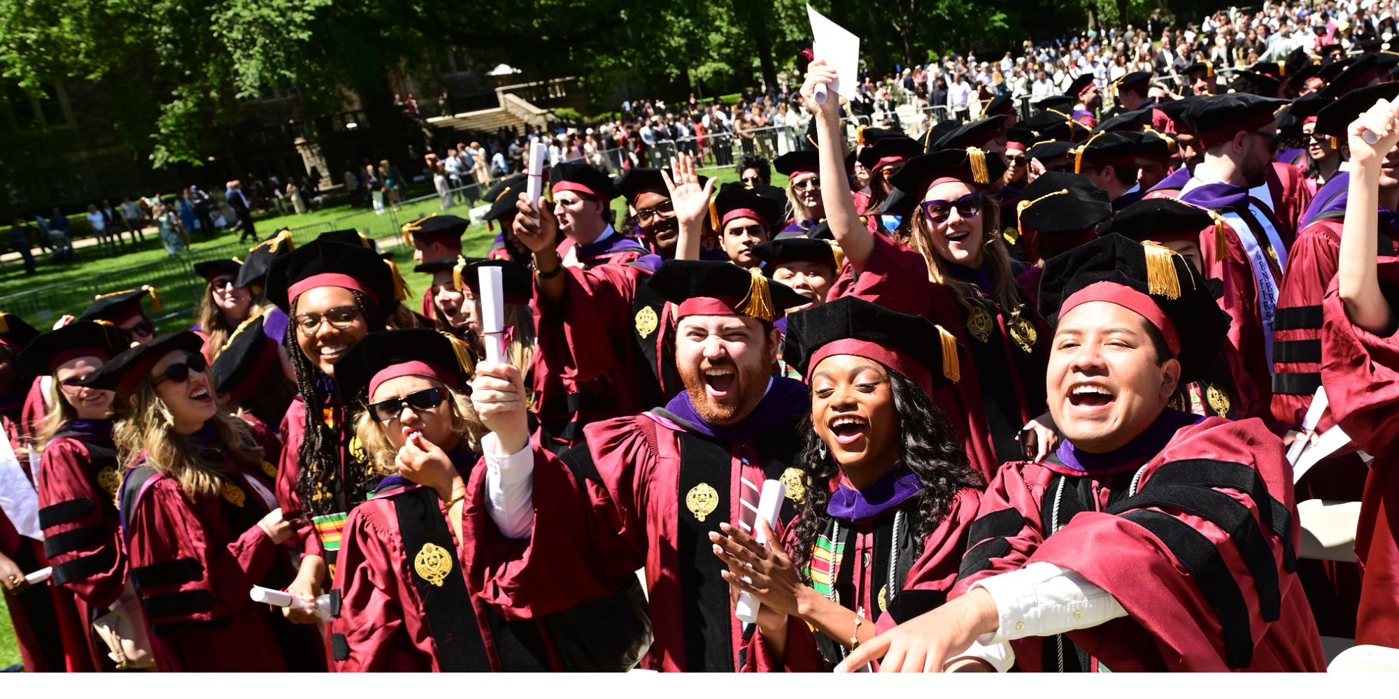 crowd of Fordham Law students at diploma ceremony cheer in excitement