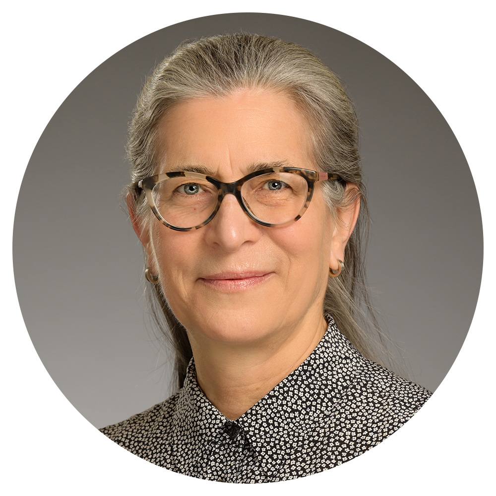 A woman wearing glasses and a black and white shirt.