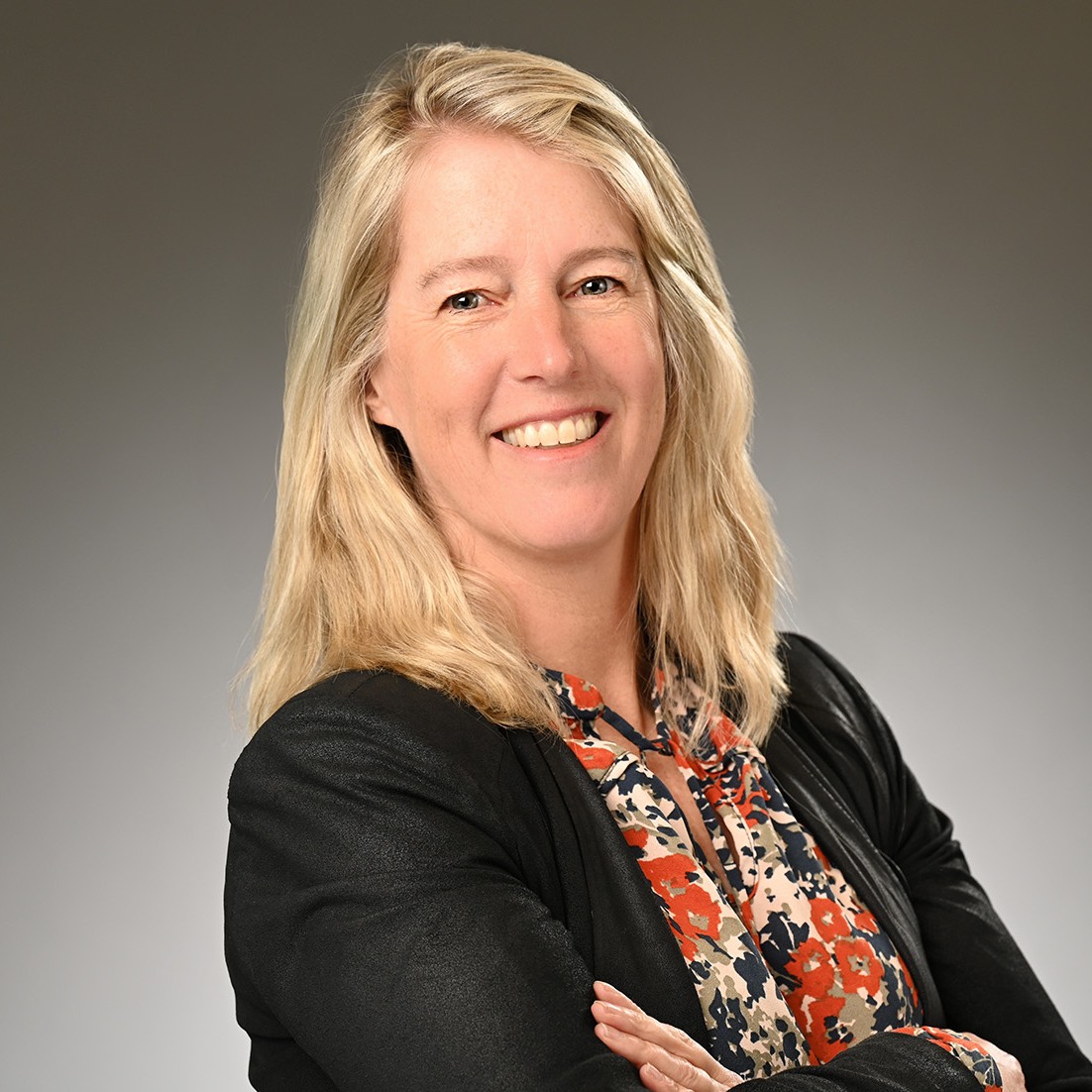 A woman with blond hair wearing a black blazer.