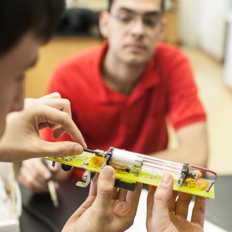 Students examining circuit board - LG