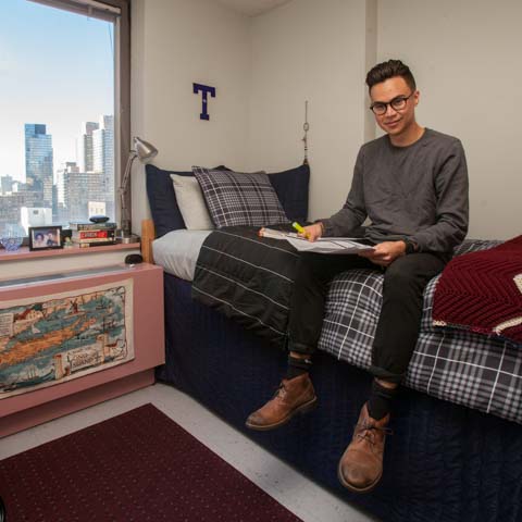 Male Student on Bed in Dorm Room