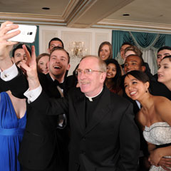 Father McShane takes selfie with students at Founder's Gala