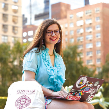 Fordham Student Sitting with a Laptop.