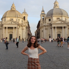 Student stands in front of European buildings