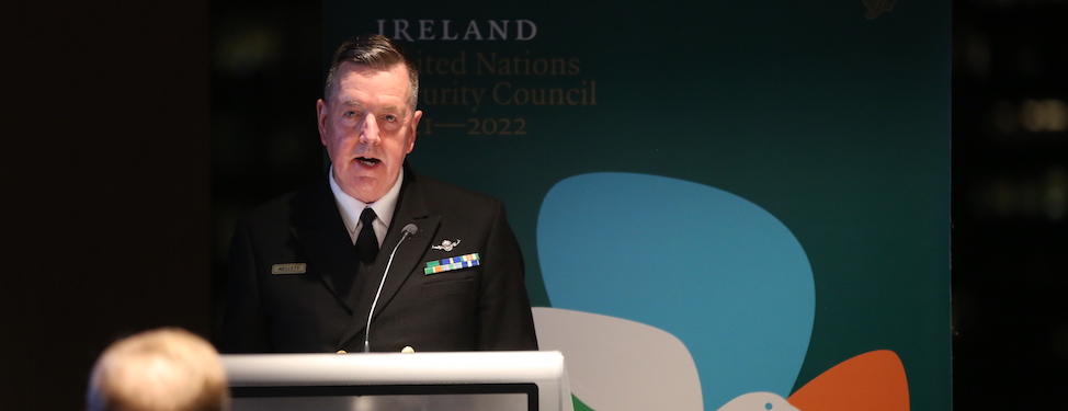 Vice Admiral Mark Mellett speaking at the podium in front of the Permanent Mission of Ireland to the United Nations Banner
