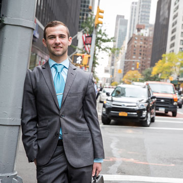 Male intern leaning on lamp post