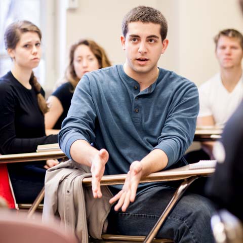 Male student emphasizing a point in class - LG