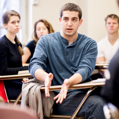 Male Student Emphasizing a Point in Class