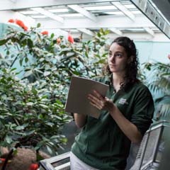 Student with clipboard in greenhouse - SM